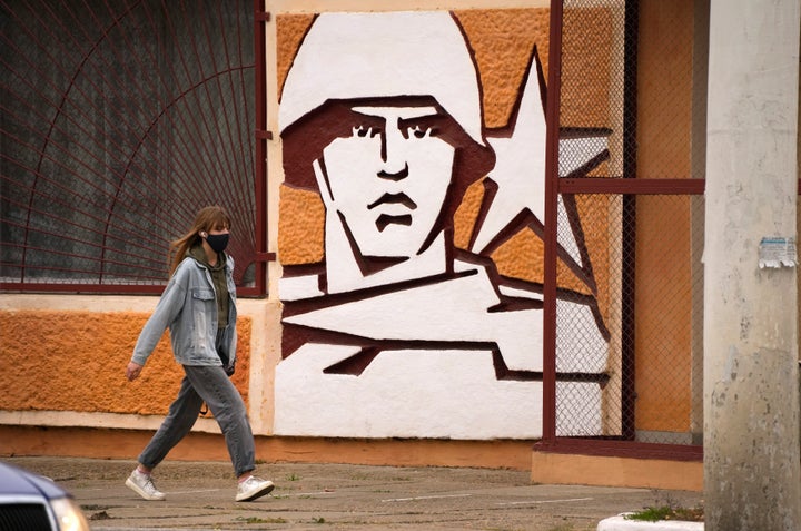 A woman walks past the Operational Group of Russian Forces headquarters in Tiraspol, the capital of the breakaway region of Transnistria, a disputed territory unrecognized by the international community, in Moldova, Nov. 1, 2021.