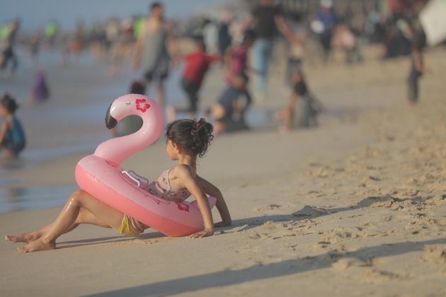 DEIR AL BALAH, GAZA - JULY 11: Palestinians try to cool themselves off and enjoy at the sea shores during hot weather in Deir Al Balah, Gaza on July 11, 2024. They want to relieve themselves and their children as Israeli air, sea and land attacks on the Gaza Strip continue. (Photo by Hassan Jedi/Anadolu via Getty Images)