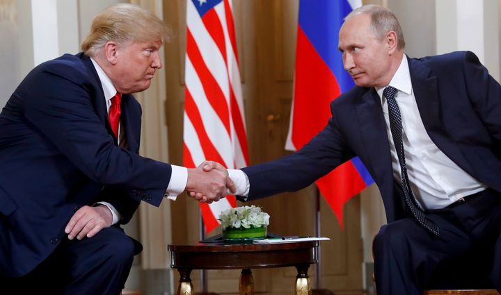 Donald Trump, left, and Russian President Vladimir Putin shake hands at the beginning of a meeting at the Presidential Palace in Helsinki, Finland, July 16, 2018.