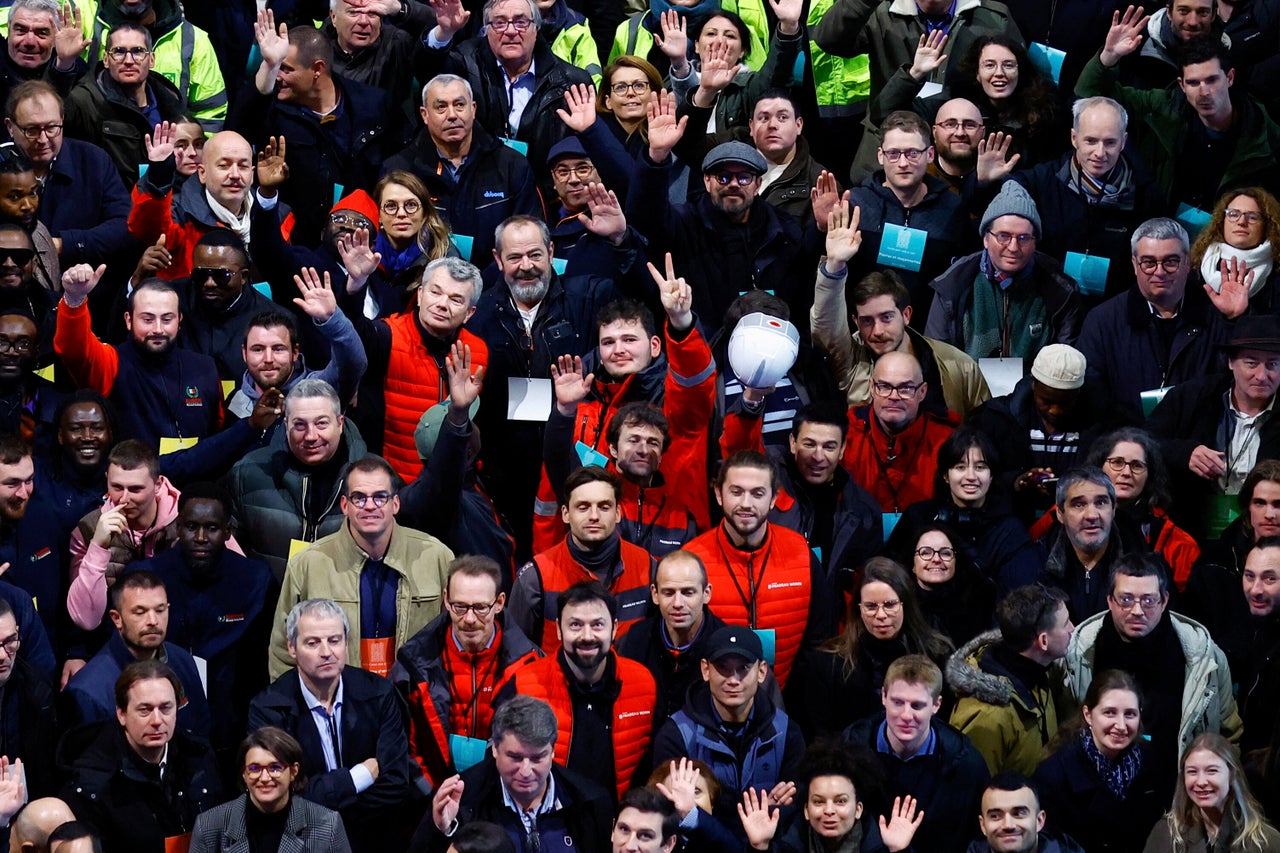 Construction workers applaud after Macron delivered a speech while visiting the restored interiors of the cathedral.