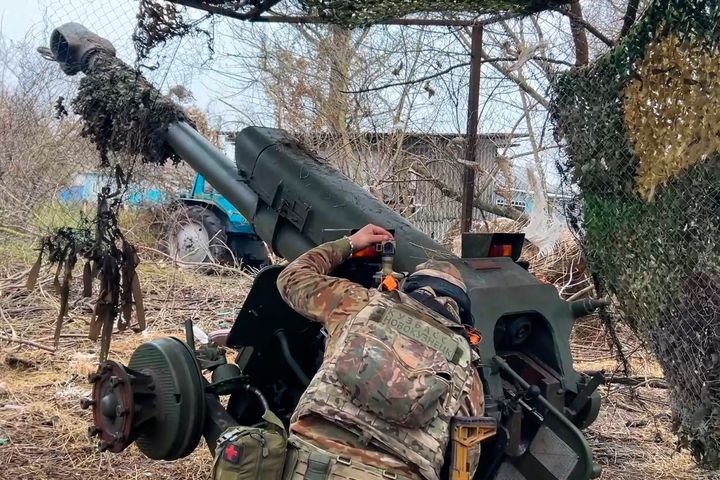 Russian serviceman aims a D-30 howitzer towards Ukrainian positions in the border area of Kursk region, Russia. 