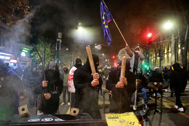 Demonstrators knock with sticks at a barricade during protests against the government's decision to suspend negotiations on joining the European Union in Tbilisi, Georgia, early Tuesday, Dec. 3, 2024. 