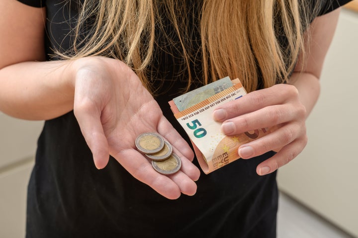 Woman holding paper money and coins in European currency, euro, currency exchange rate