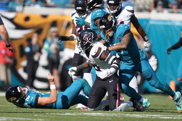 Jacksonville Jaguars tight end Evan Engram (17) pushes Houston Texans linebacker Azeez Al-Shaair (0) from behind after his hit on Jacksonville Jaguars quarterback Trevor Lawrence (16) during an NFL football game, Sunday, Dec. 1, 2024, in Jacksonville, Fla. (AP Photo/Peter Joneleit)