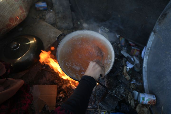 ガザ地区デイル・アル=バラにある難民キャンプのテントで、4人の子どものためにレンズ豆を煮込むヤスミン・エイドさん