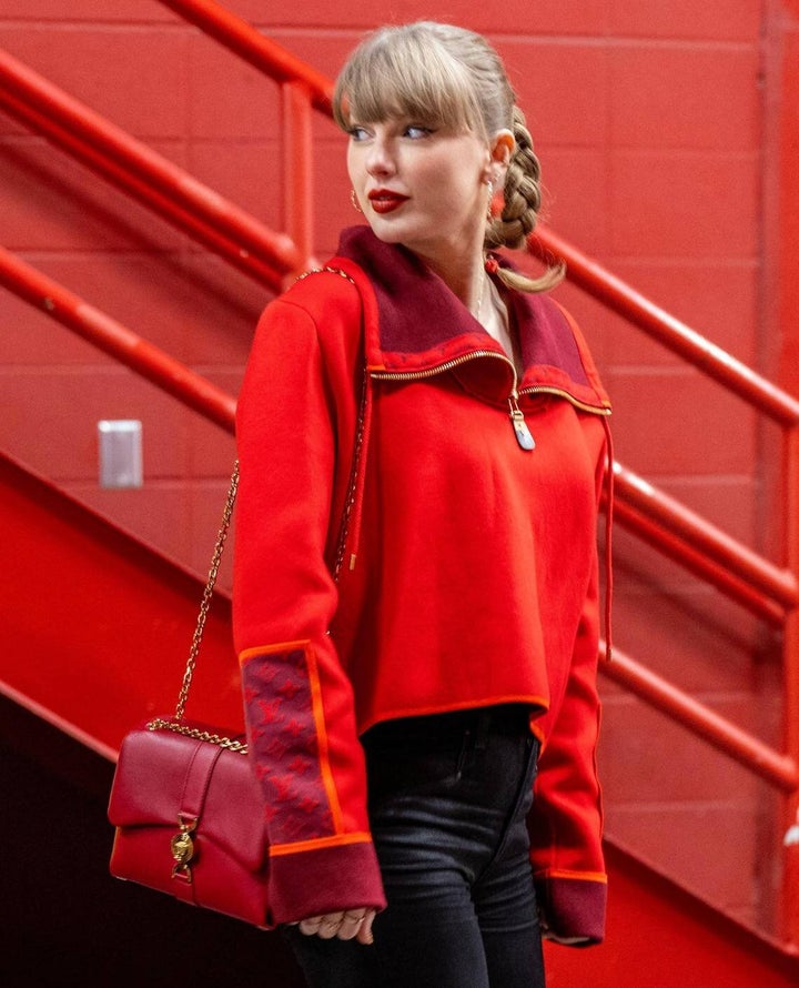 Η Taylor Swift στο Arrowhead Stadium φορώντας ένα κομψό, κοφτό παλτό Louis Vuitton με μισό φερμουάρ και ένα στενό μαύρο τζιν. 