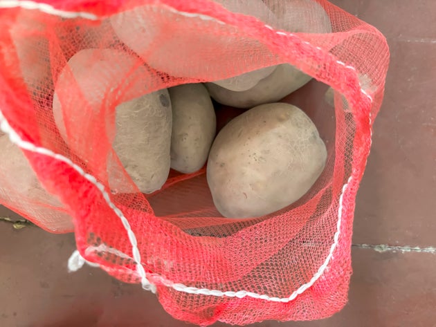Potatoes in a grid. Packed potatoes in a net. red mesh with whole potatoes.