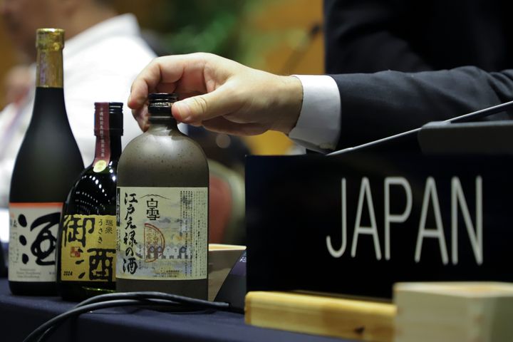 Japanese sake, that is listed as a nominee for Intangible Cultural Heritage, are displayed on Japan's delegation table, during an UNESCO World Heritage Convention, in Asuncion, Paraguay, Wednesday, Dec. 4, 2024. (AP Photo/Marta Escurra)