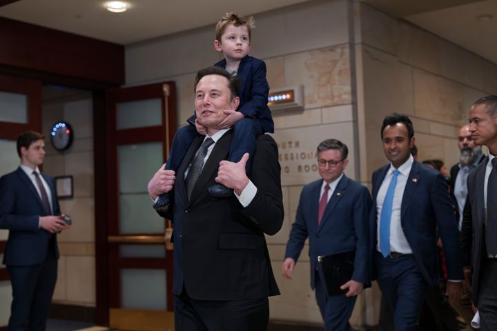 Elon Musk, from left, carries his son X Æ A-Xii, joined by Speaker of the House Mike Johnson, R-La., and Vivek Ramaswamy, as they convene a meeting of President-elect Donald Trump's planned Department of Government Efficiency, or DOGE, at the Capitol on Thursday.