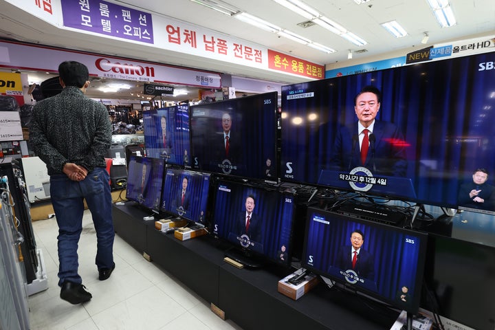 SEOUL, SOUTH KOREA - DECEMBER 07: TV screens show footage of South Korean President Yoon Suk Yeol delivering an address to the nation at the Yongsan Electronic store on December 07, 2024 in Seoul, South Korea. South Korea is facing significant political turmoil after President Yoon Suk-yeol declared emergency martial law, accusing opposition parties of destabilizing governance and sympathizing with North Korea. His controversial move, since rescinded after a 190-0 vote by lawmakers condemning the move, has sparked widespread criticism, calls for Yoon's resignation, and raised concerns about the implications for democracy in the country. (Photo by Chung Sung-Jun/Getty Images)