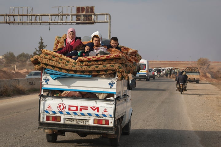 Residents leave the city carrying their belongings in the aftermath of the opposition's takeover of Hama, Syria, Friday, Dec. 6, 2024. (AP Photo/Ghaith Alsayed)