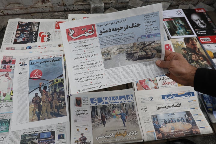 A man holds a local newspaper with the front page news on the fall of the Syrian capital Damascus in rebel hands at a news stand in Tehran on December 8, 2024. (Photo by ATTA KENARE / AFP) / (Photo by ATTA KENARE/AFP via Getty Images)