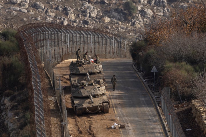 Israeli soldiers stand by tanks near the border with Syria on Dec. 9, 2024, in occupied Golan Heights. Israeli Prime Minister Benjamin Netanyahu has ordered his military to temporarily take control of a buffer zone that was created as part of a 1974 ceasefire deal between the two countries.