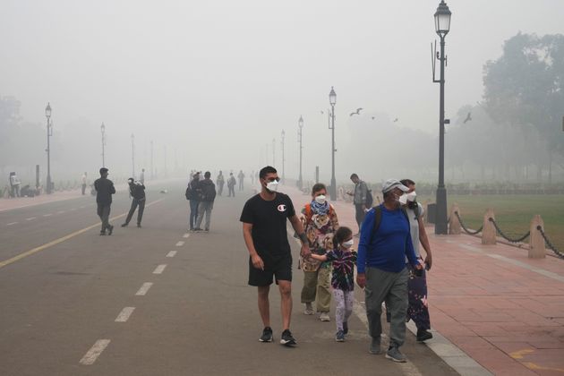 Τουρίστες φορούν μάσκα εξαιτίας της ατμοσφαιρικής ρύπανσης στο Νέο Δελχί στην Ινδία.