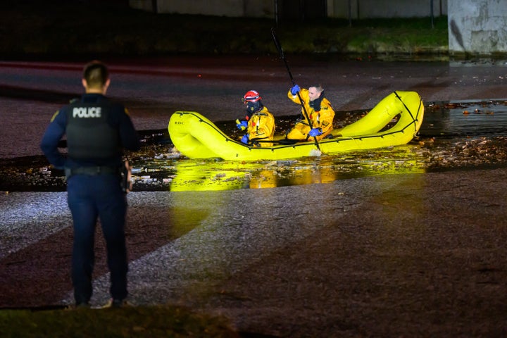 Public safety officials look for a body in the Washington Park Lake on Saturday.