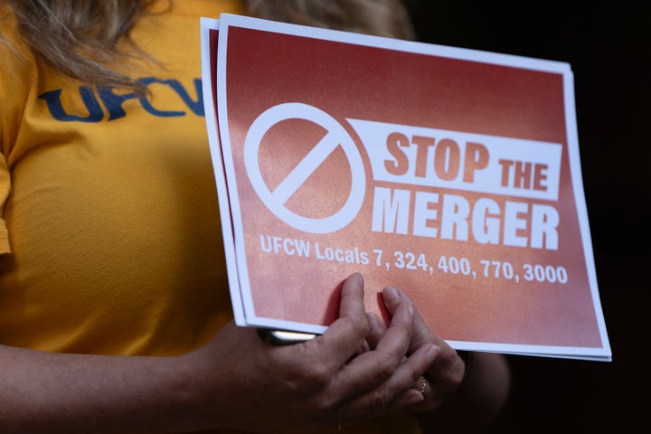 Faye Guenther, president of local UFCW 3000, holds a sign during a news conference about the Kroger and Albertsons merger outside the federal courthouse on Aug. 26 in Portland, Oregon.