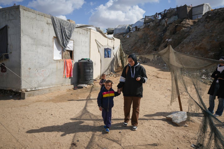 Reem Ajour walks with her son, Wael, at a camp outside Zuweida, Gaza Strip, Nov. 20, 2024.