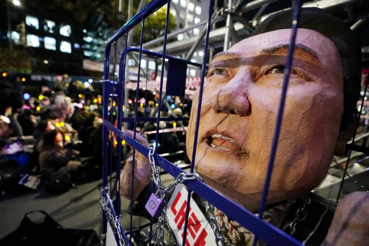 A caricature depicting an imprisoned South Korean President Yoon Suk Yeol is displayed during a rally to demand his impeachment outside the National Assembly in Seoul, South Korea, Friday, Dec. 13, 2024. (AP Photo/Ahnn Young-joon)