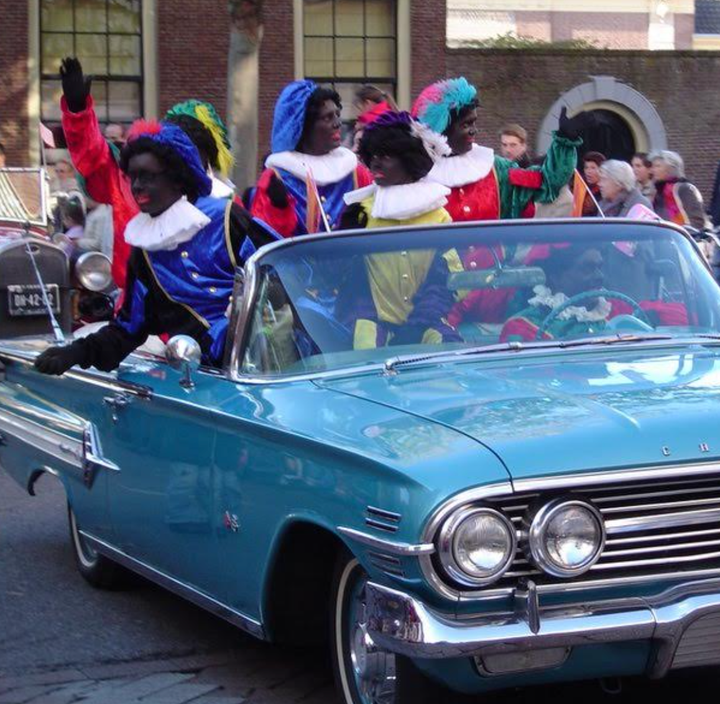 Black Petes ride in a classic blue Chevrolet convertible during a 2005 parade in the Dutch city of Haarlem.