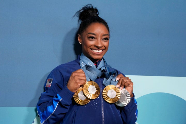 Simone Biles holds up her medals after the women's artistic gymnastics individual apparatus finals at the 2024 Summer Olympics in Paris, France. 