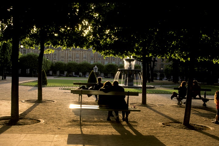 Couples gather at sunset in Place des Vosges park situated in the Marais area of Paris. 