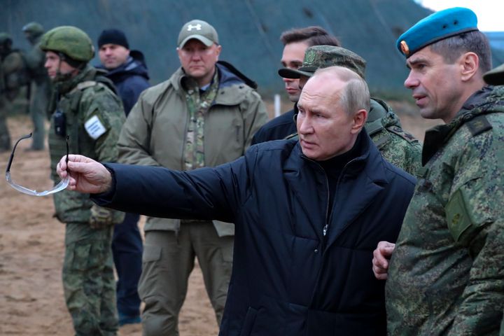 Russian President Vladimir Putin, second right, gestures as he visits with Deputy Commander of the Airborne Troops Anatoly Kontsevoy, right.