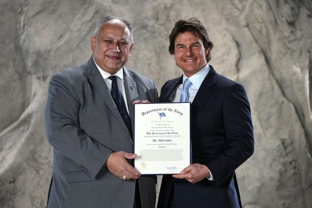 Ο Τομ Κρουζ με τον υπουργό Ναυτικού των ΗΠΑ, Κάρλος Ντελ Τόρο κατά την απονομή, στα Longcross South Studios, Βρετανία, 17 Δεκεμβρίου 2024. (AP Photo/Kin Cheung)