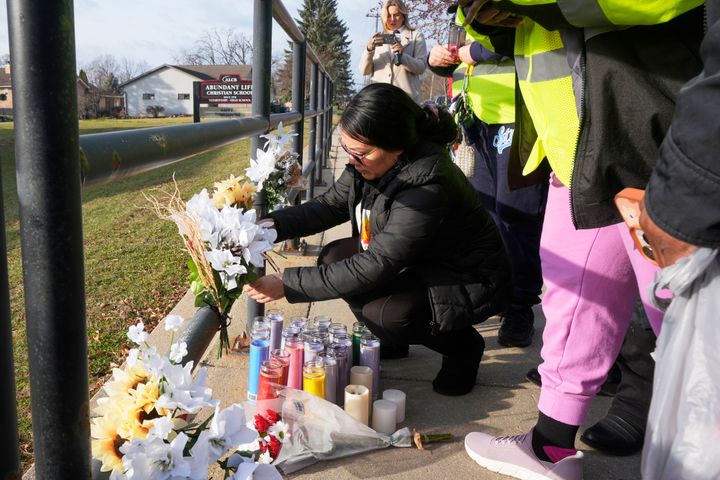 A resident places flowers outside the Abundant Life Christian School on Dec. 17, 2024, in Madison, Wisconsin, following a shooting there on Monday. 