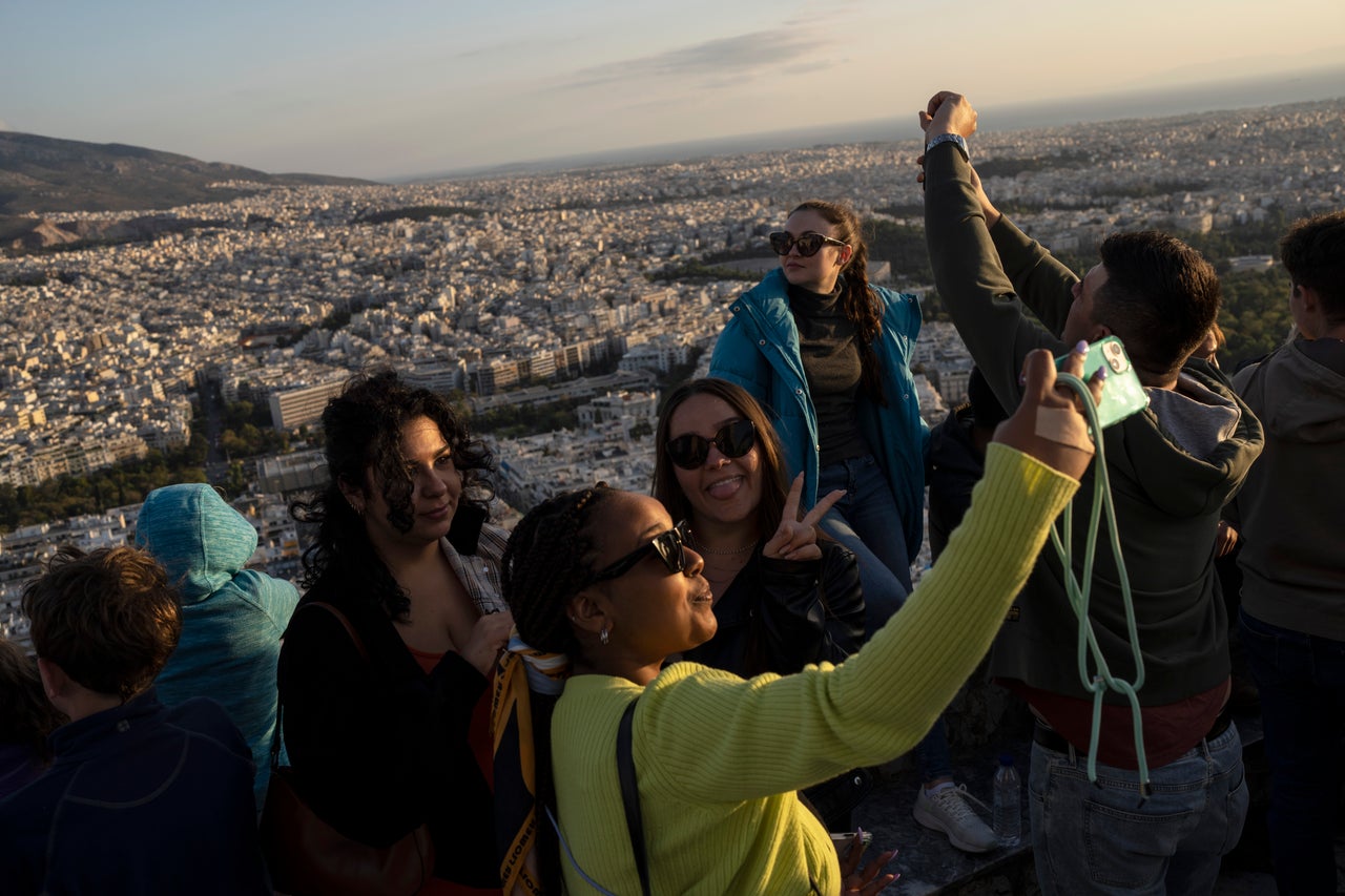 Τουρίστες βγάζουν φωτογραφίες στην κορυφή του λόφου του Λυκαβηττού στην Αθήνα , την Τρίτη 18 Οκτωβρίου 2022. (AP Photo/Petros Giannakouris)