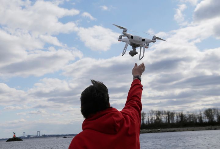 A drone operator helps to retrieve a drone after photographing over Hart Island in New York. Residents in New Jersey have reported more than 5,000 drone sightings to the FBI in the last few weeks.