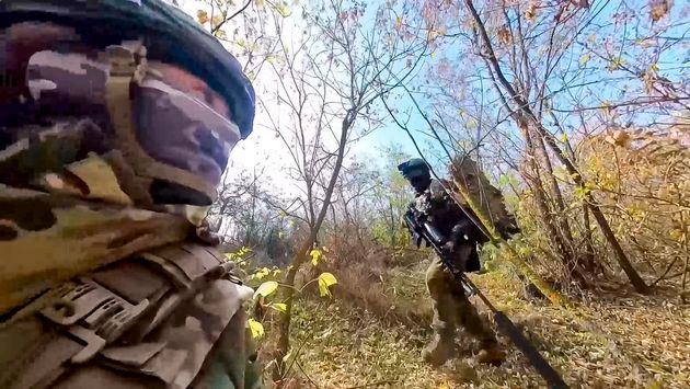 In this photo taken from video released by the Russian Defense Ministry Press Service on Tuesday, Nov. 26, 2024, a couple of Russian Army snipers walk changing their position while fighting with Ukrainian Armed forces at an undisclosed location in Ukraine.