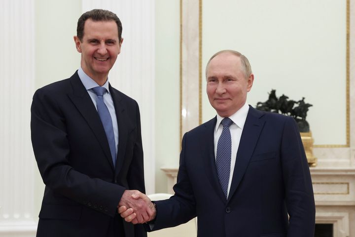 Then-Syrian President Bashar Assad, left, and Russian President Vladimir Putin shake hands during their meeting in Moscow, July 24, 2024.