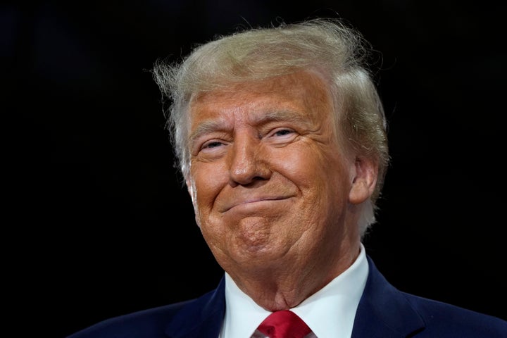 Former President Donald Trump smiles as he arrives at a commit to caucus rally, on Oct. 16, 2023, in Adel, Iowa.