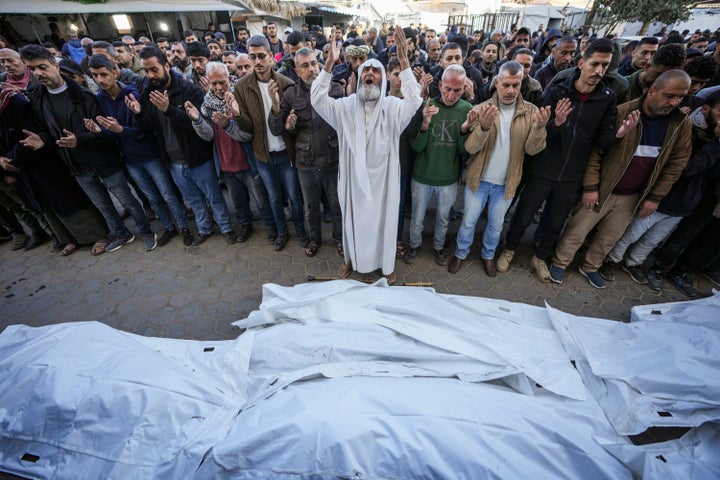 Palestinians pray over the bodies of the victims of an Israeli strike on a home late Saturday before the funeral outside the Al-Aqsa Martyrs Hospital in Deir al-Balah Sunday, Dec. 22, 2024. At least eight people were killed according to the hospital which received the bodies. (AP Photo/Abdel Kareem Hana)