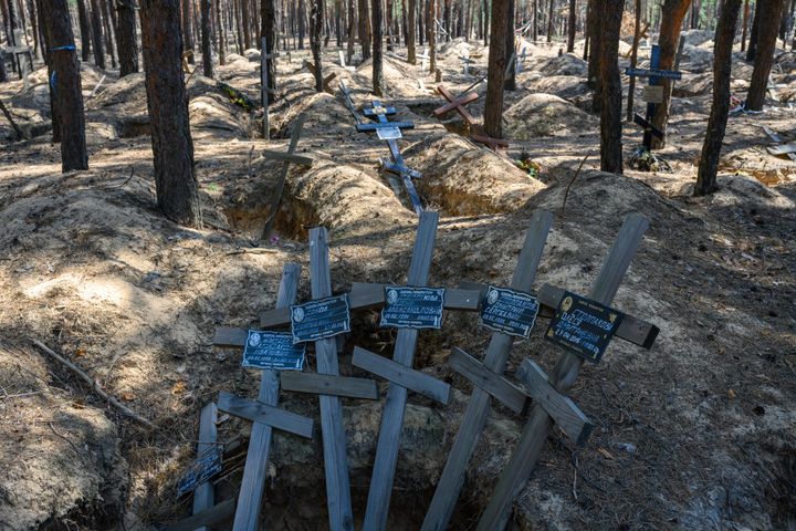 ΙΖΙΟΥΜ, ΟΥΚΡΑΝΙΑ - 18 ΙΟΥΛΙΟΥ: Ξεθωριασμένοι ξύλινοι σταυροί και αστυνομική ταινία σηματοδοτούν το σημείο όπου ουκρανοί ιατροδικαστές και ερευνητές εγκλημάτων πολέμου εκταφίασαν τα πτώματα 447 Ουκρανών από ένα χώρο ταφής που δημιουργήθηκε κατά τη διάρκεια της εξάμηνης ρωσικής κατοχής το 2022, στις 18 Ιουλίου 2024 στο Ιζιούμ της Ουκρανίας. Σε αυτό το νεκροταφείο πευκοδάσους του Izyum, ορισμένα πτώματα φέρεται να βρέθηκαν με δεμένα χέρια ή σκοτωμένα με θραύσματα ή σφαίρες, σε στυλ εκτέλεσης. (Φωτογραφία: Scott Peterson/Getty Images)