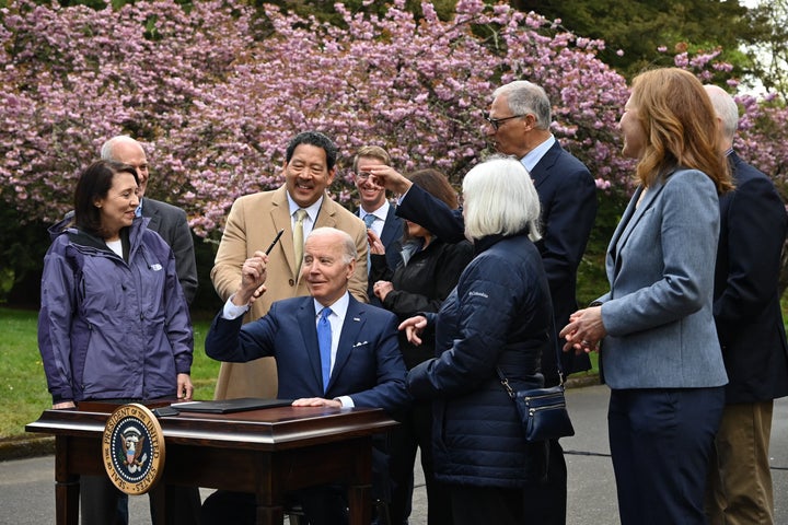 President Joe Biden holds up a pen after signing an executive order aimed at safeguarding ancient trees during an Earth Day event in Seattle on April 22, 2022.