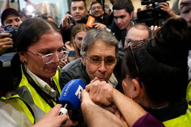 Ο Fabio Ochoa, κέντρο, πρώην μέλος του καρτέλ του Μεντεγίν, φιλάει το χέρι ενός συγγενή του κατά την άφιξή του στο αεροδρόμιο El Dorado, μετά την απέλασή του από τις Ηνωμένες Πολιτείες, στην Μπογκοτά της Κολομβίας, Δευτέρα, 23 Δεκεμβρίου 2024. (AP Photo/Fernando Vergara)