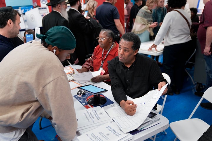 Poll workers help guide voters through a busy polling place in the Brooklyn borough of New York, November 5, 2024. (AP Photo/Seth Wenig, File)