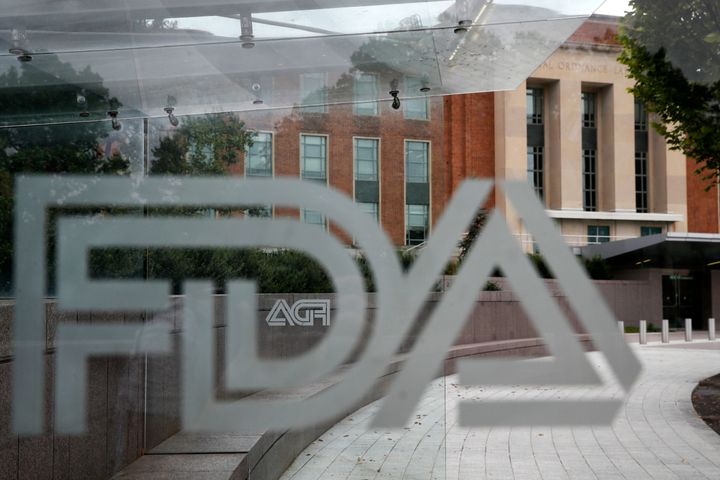 A U.S. Food and Drug Administration building is seen behind FDA logos at a bus stop on the agency's campus in Silver Spring, Md., on Aug. 2, 2018. (AP Photo/Jacquelyn Martin, File)