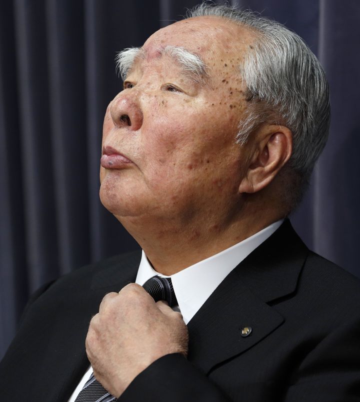 Osamu Suzuki, chairman of Suzuki Motor Corp., adjusts his tie during a news conference at the Ministry of Land, Infrastructure, Transport and Tourism in Tokyo, Japan, on Wednesday, May 18, 2016. Suzuki Motor Corp. said it used fuel-economy testing methods that were different from local regulations on about 2.1 million vehicles in Japan. The automaker won't need to revise the ratings as proper testing showed the results fall within an acceptable range of deviation. Photographer: Tomohiro Ohsumi/Bloomberg via Getty Images 