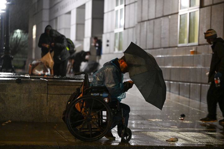 Homeless people are seen near San Francisco City Hall during heavy rain this week.