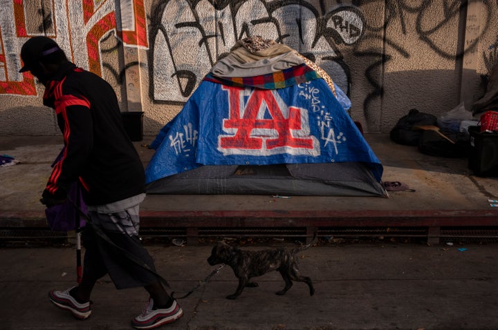 A man walks past a homeless encampment in downtown Los Angeles last year.