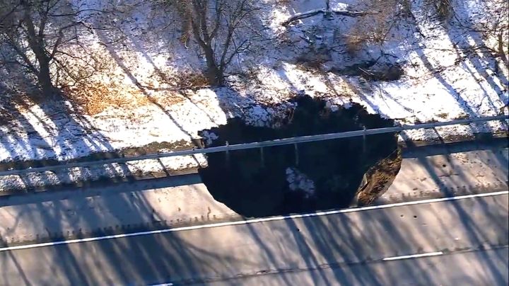 Work crews look on as a sinkhole opened up along Interstate 80 near Wharton, N.J. on Thursday, Dec. 26, 2024. (WABC-TV via AP)