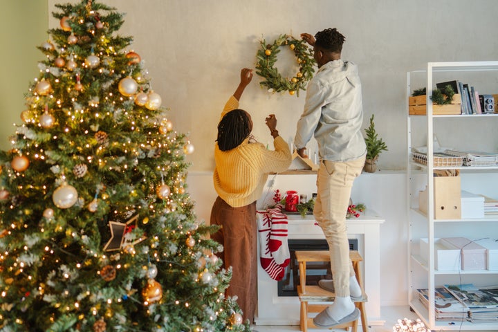 Photo of a lovely couple decorating their home with Christmas ornaments, expressing their love and affection for each other