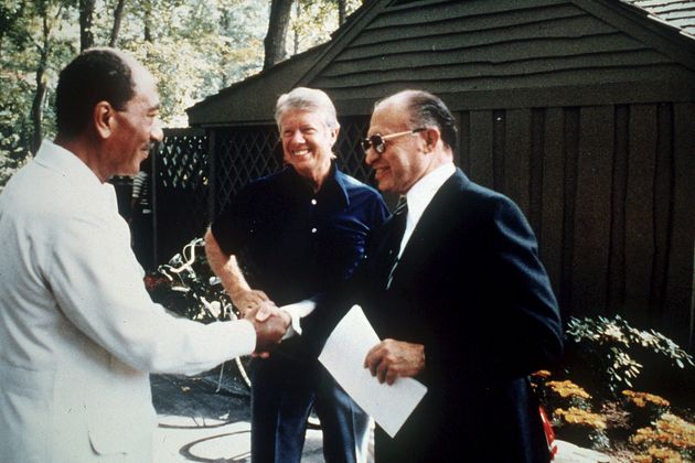 Egypt's President Anwar Sadat (left) shakes hands with Israeli Prime Minister Menachem Begin as U.S. President Jimmy Carter (center) looks on at Camp David, Maryland, on Sept. 7, 1978.