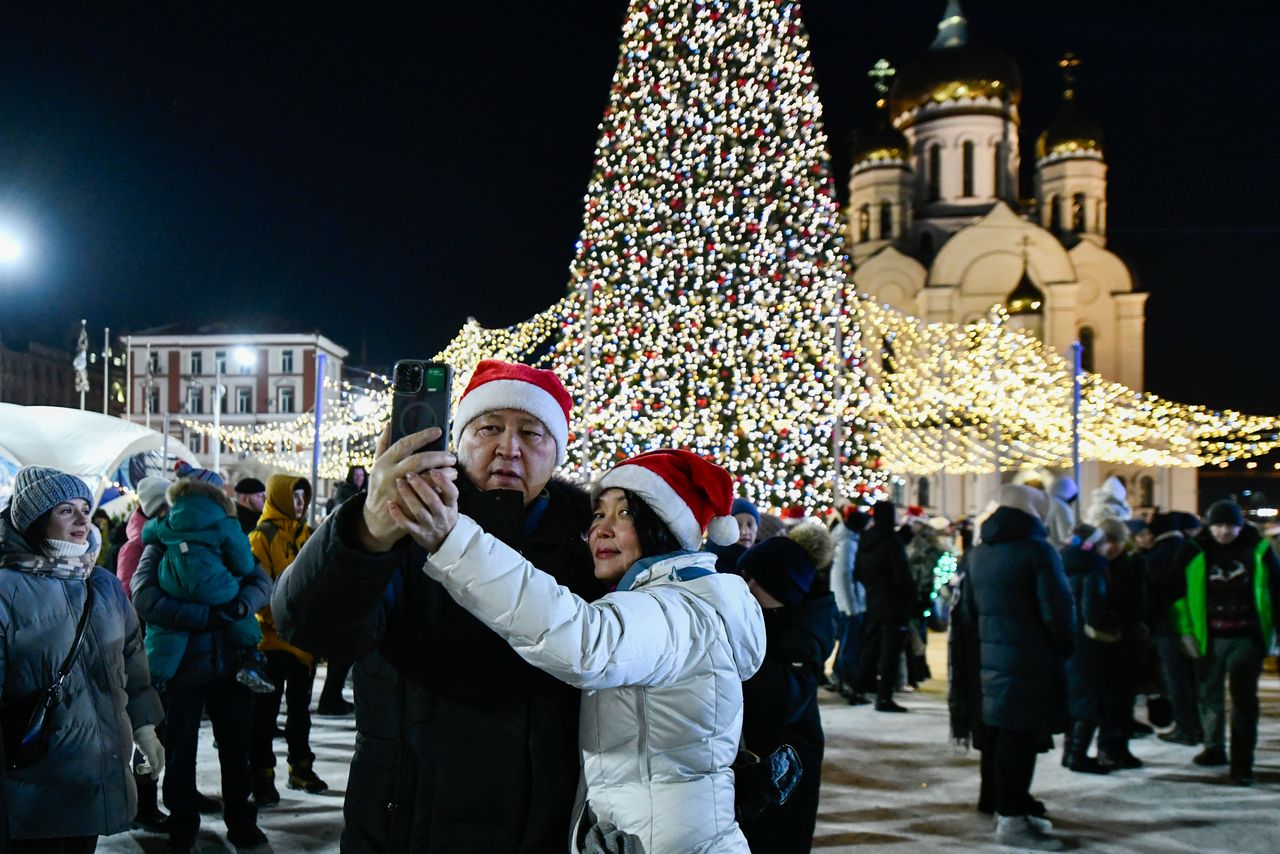 Ένα ζευγάρι βγάζει selfie καθώς άλλοι άνθρωποι συγκεντρώνονται στο κέντρο του ρωσικού λιμανιού του Βλαδιβοστόκ, Ρωσία, Τρίτη 31 Δεκεμβρίου 2024, για να γιορτάσουν το νέο έτος 2025. Μακριά από το πολεμικό μέτωπο της Ουκρανίας, όπου ρωσικές επιθέσεις συνεχίζονται και σήμερα... (AP Photo)