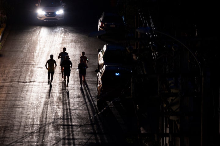 Joggers exercise on a dark street in San Juan, Puerto Rico, after a major power outage hit the island on Dec. 31, 2024.