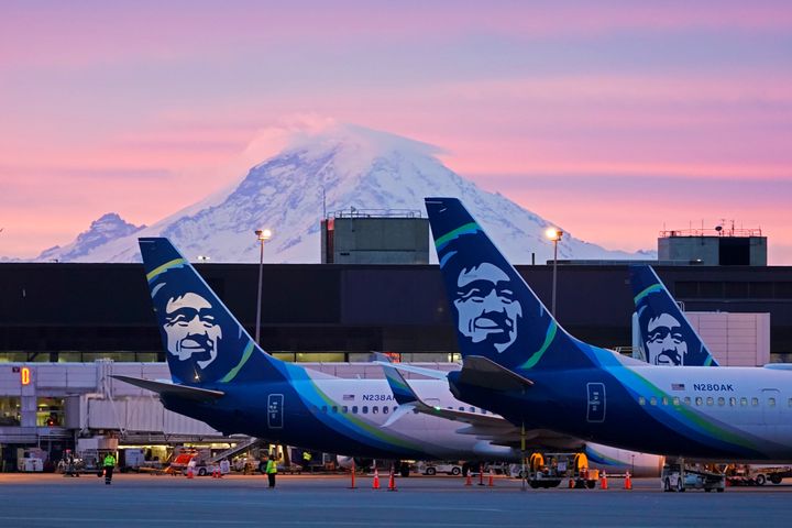 Alaska Airlines planes are shown parked at gates with Mount Rainier in the background at sunrise, March 1, 2021, at Seattle-Tacoma International Airport in Seattle. (AP Photo/Ted S. Warren)