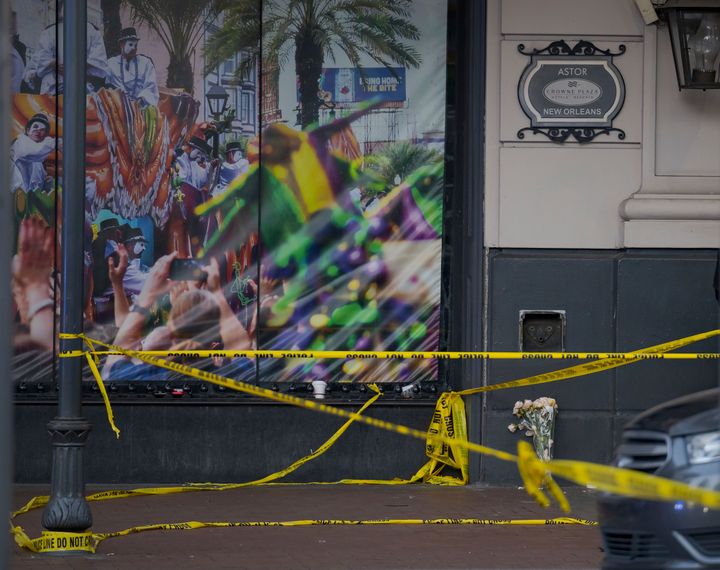 A man left a bouquet of flowers at the intersection of Bourbon Street and Canal Street during the investigation after a pickup truck rammed into a crowd of revelers early on New Year's Day, on Jan. 1, 2025, in New Orleans.