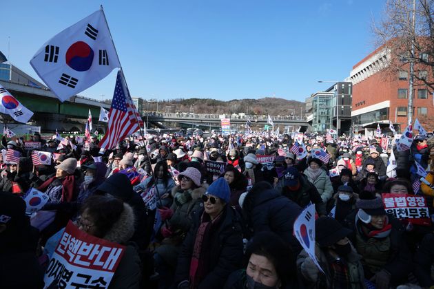 Supporters of impeached South Korean President Yoon Suk Yeol stage a rally to oppose a court having issued a warrant to detain Yoon, near the presidential residence in Seoul, South Korea, Friday, Jan. 3, 2025. The letters read, 